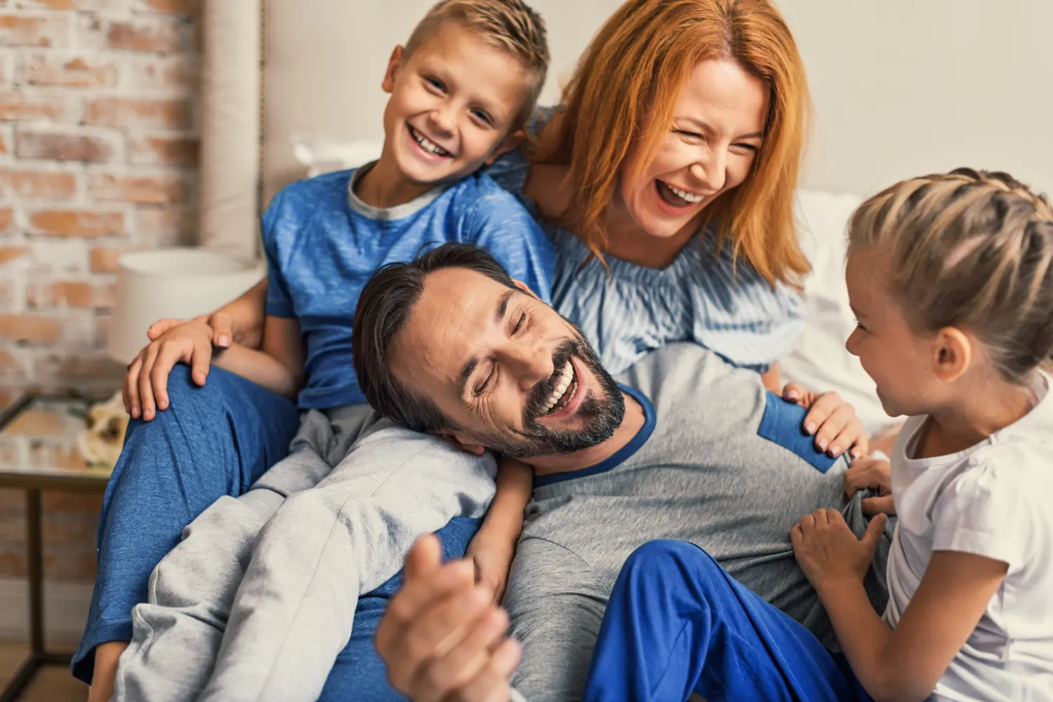Glückliche Familie auf dem Bett liegend zu Hause